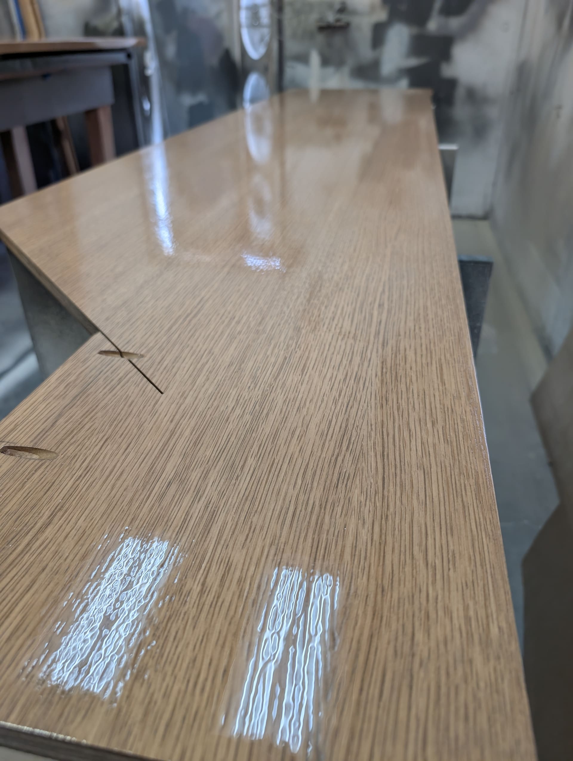 Detail of a lacquer-finished cabinet surface showing rich wood grain and sheen