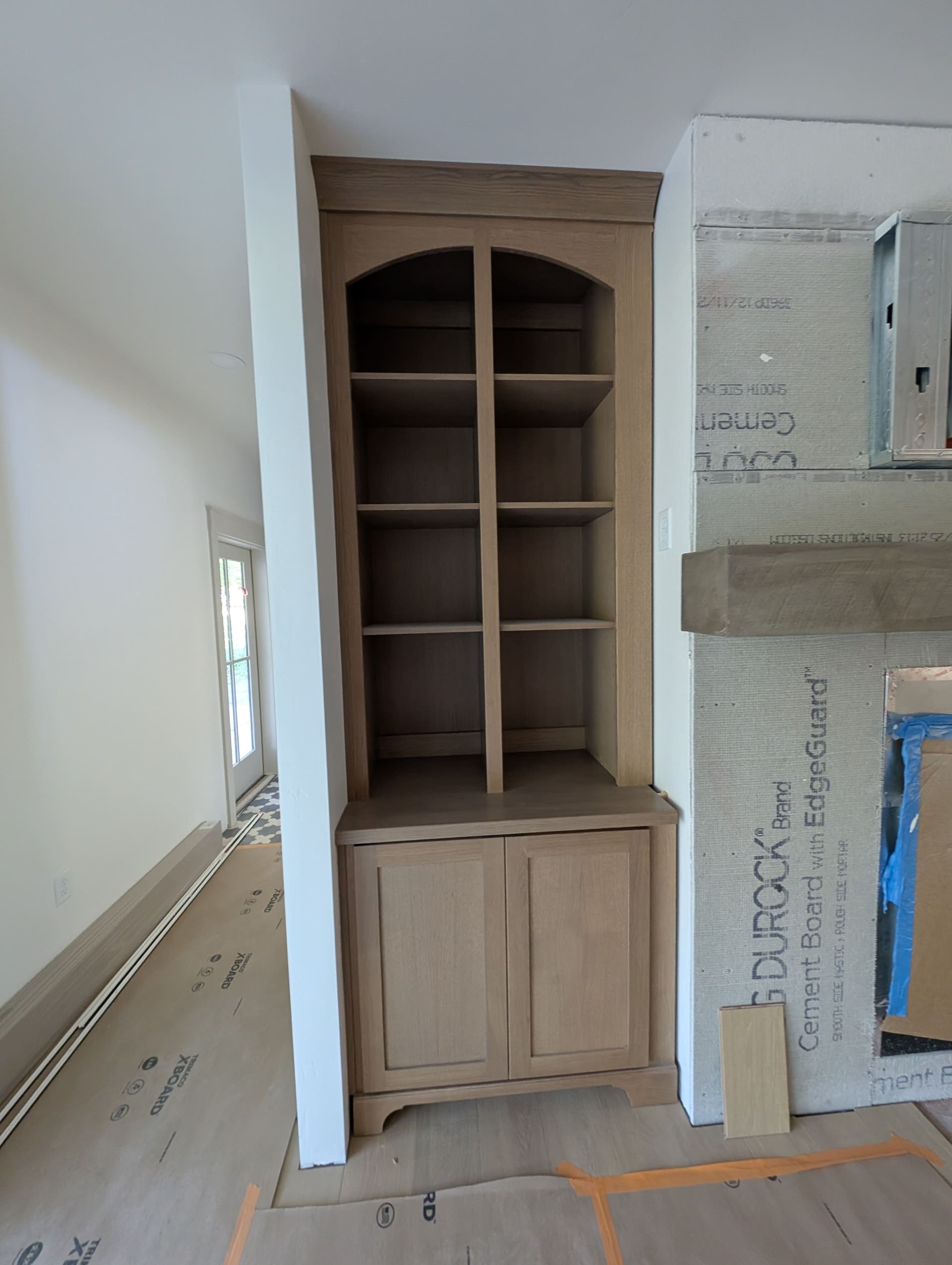 Custom built-in bookcase with arched cabinet doors and open shelving