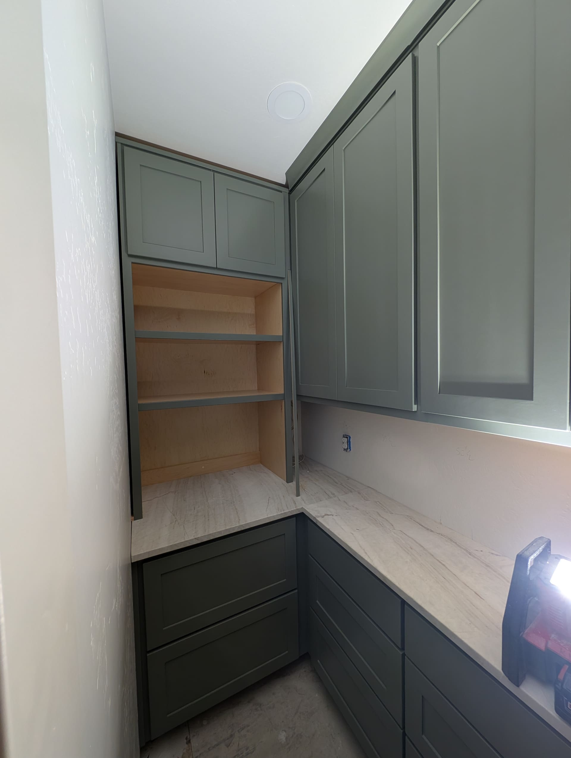 Custom pantry cabinetry in sage green with open shelving and marble countertop